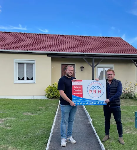 Deux membres de Pro Réno Home tenant un panneau de l'entreprise dans l'allée d'une maison